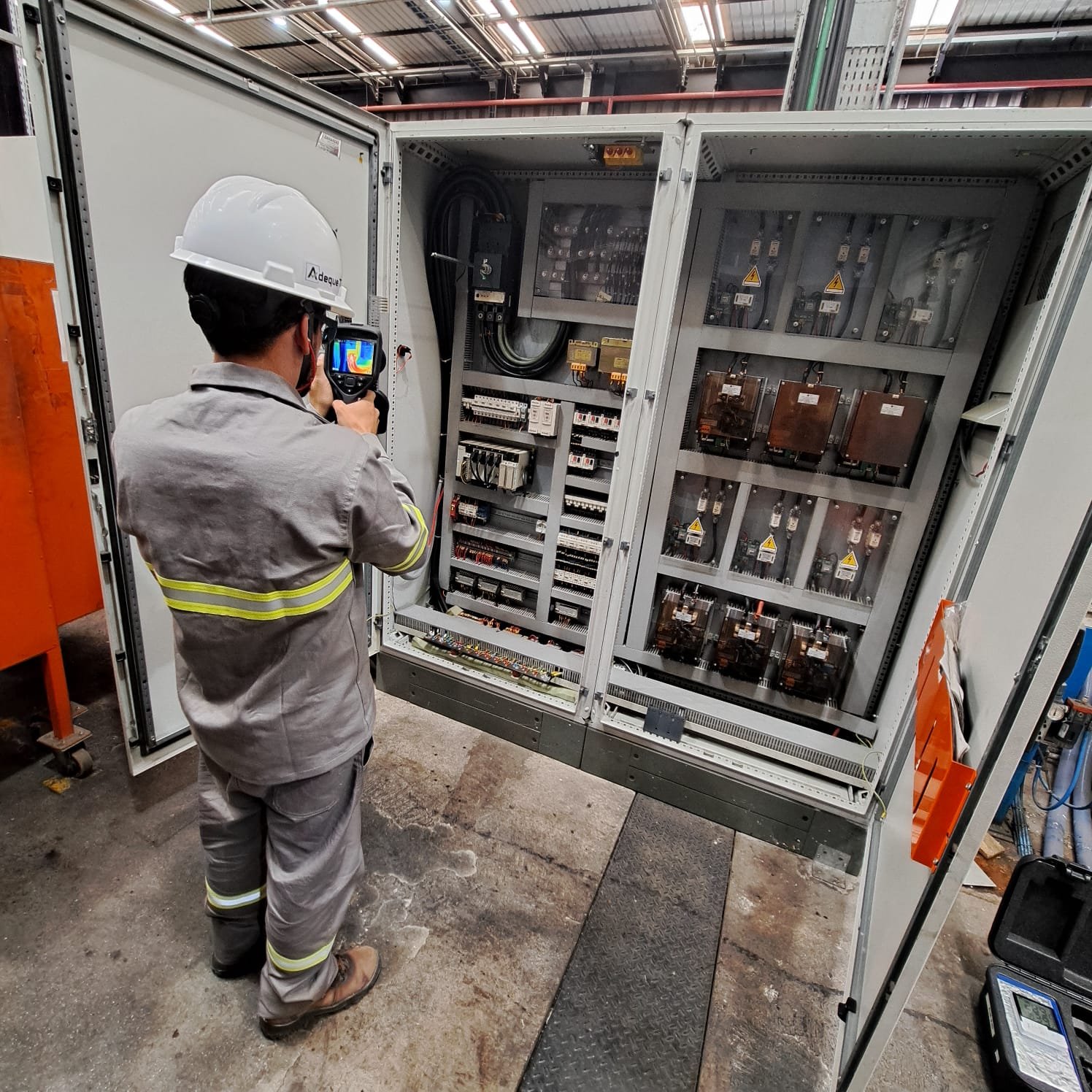 Profissional da Adeque-T realizando inspeção termográfica em painéis elétricos industriais