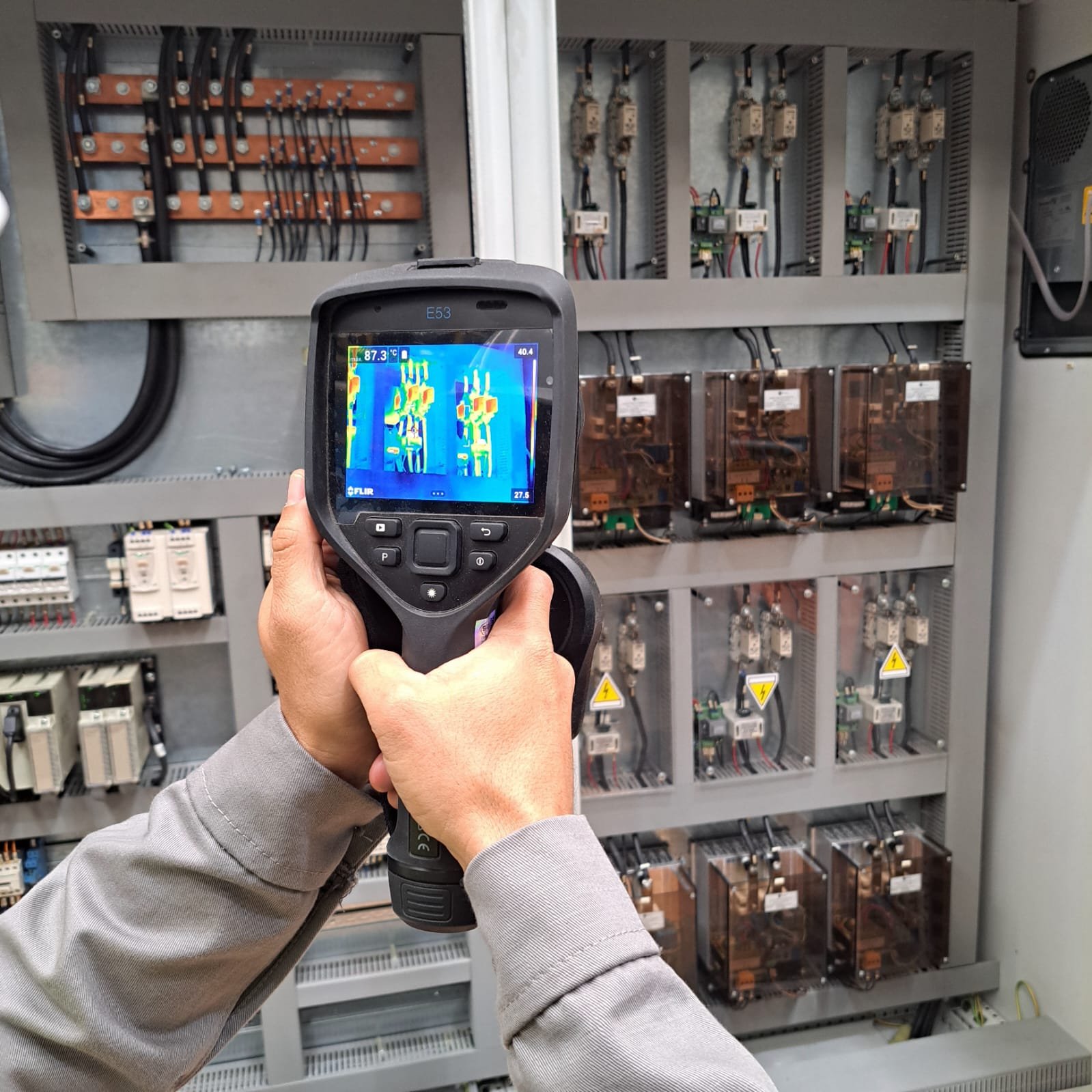 Câmera termográfica registrando temperaturas de componentes em painel elétrico